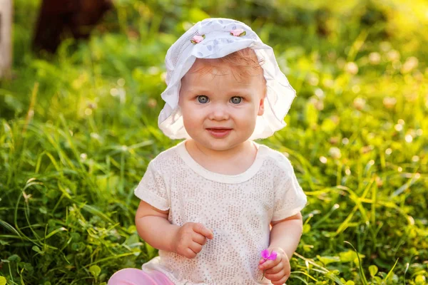 Γλυκό ευτυχισμένο μωρό κοριτσάκι κάθεται στο γρασίδι στο πάρκο, Κήπος, Λιβάδι — Φωτογραφία Αρχείου