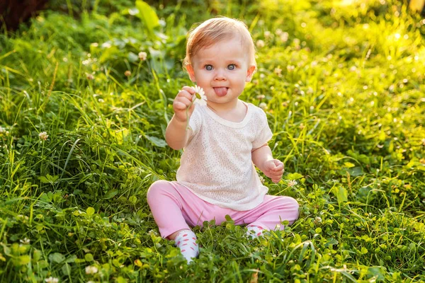 Zoete happy babymeisje zittend op het gras in park, Tuin, weide — Stockfoto