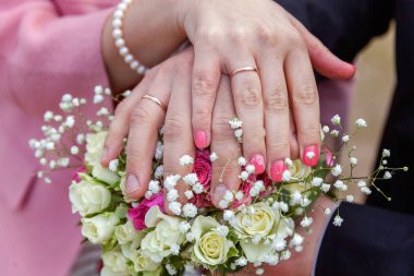 Alyans karşı arka planını çiçekler gelin buketi gelin ve damat elleriyle