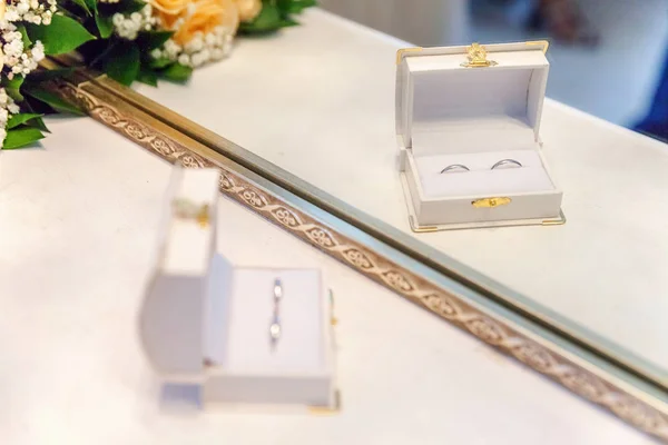 Due belle fedi nuziali su scatola di gioielli bianchi su sfondo chiaro — Foto Stock