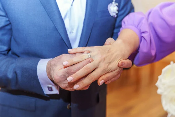 Brudgummen hand sätta vigselringen på bruden finger — Stockfoto