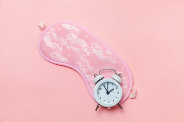 Uyku maskesi ve pastel pembe çalar saat