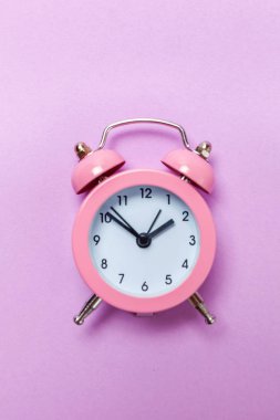 Vintage çalar saat göl kenarında mor Menekşe pastel arka plan üzerinde