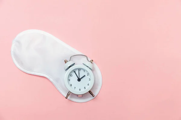 Sovemaske og vekkerklokke på rosa pastellbakgrunn – stockfoto
