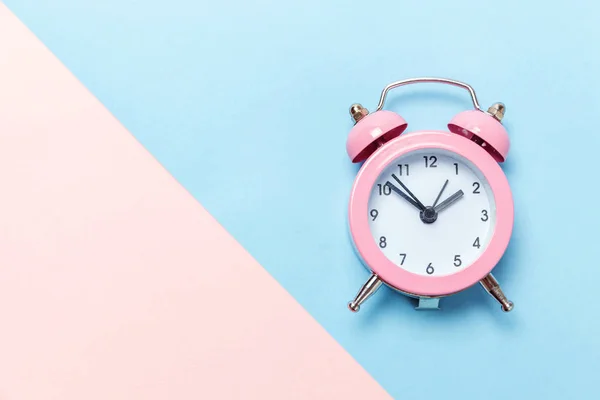 Vintage väckarklocka isolerade på blå och rosa pastell bakgrund — Stockfoto