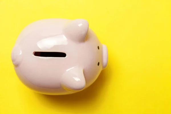 Pink piggy bank isolated on yellow background