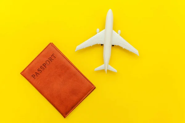Mínimo simple plano laico viaje aventura concepto de viaje con avión y pasaporte en amarillo moderno fondo de moda —  Fotos de Stock
