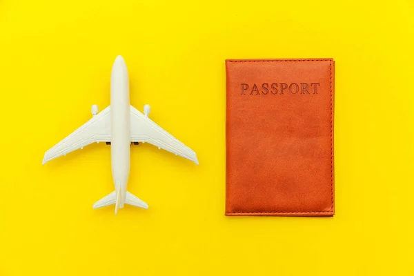 Mínimo simple plano laico viaje aventura concepto de viaje con avión y pasaporte en amarillo moderno fondo de moda —  Fotos de Stock