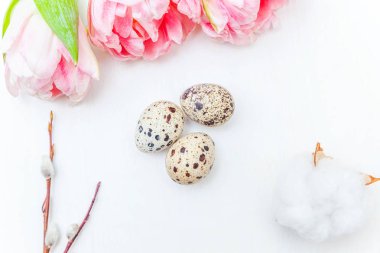 Paskalya yumurta pamuk ve pembe taze Lale buketi beyaz rustik ahşap zemin üzerinde