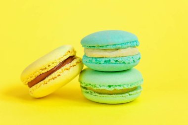 Fransız tatlı kurabiye. Çok az yiyecek ekmek kavramı. Sarı zemin üzerine mavi ve sarı macaron