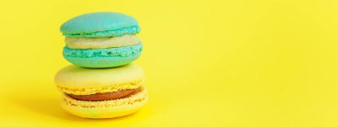 Fransız tatlı kurabiye. Çok az yiyecek ekmek kavramı. Sarı zemin üzerine mavi ve sarı macaron