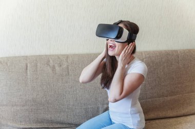 Evde sanal gerçeklik Vr gözlük kask kulaklık kullanarak giyen gülümseme genç kadın