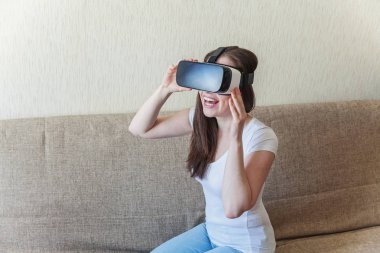 Evde sanal gerçeklik Vr gözlük kask kulaklık kullanarak giyen gülümseme genç kadın