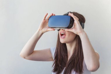 Beyaz arka plan üzerinde sanal gerçeklik Vr gözlük kask kulaklık kullanarak giyen gülümseme genç kadın