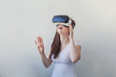 Beyaz arka plan üzerinde sanal gerçeklik Vr gözlük kask kulaklık kullanarak giyen gülümseme genç kadın