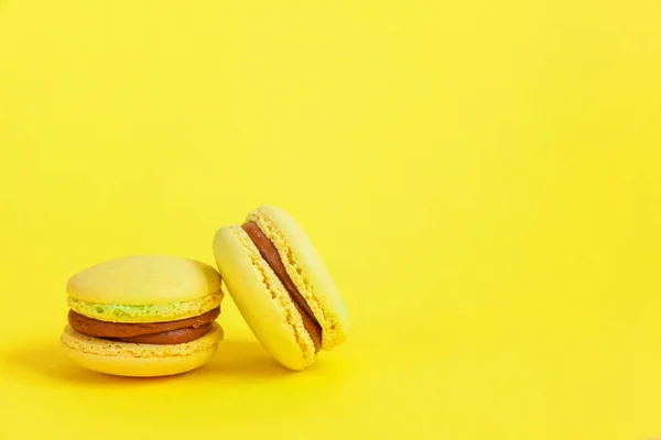 French sweet cookie. Minimal food bakery concept. Yellow macaron cake isolated on yellow background