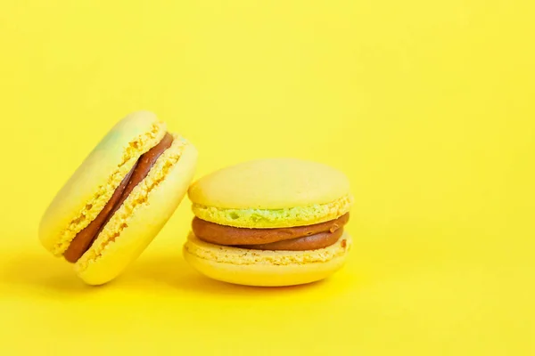 French sweet cookie. Minimal food bakery concept. Yellow macaron cake isolated on yellow background