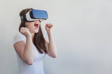 Beyaz arka plan üzerinde sanal gerçeklik Vr gözlük kask kulaklık kullanarak giyen gülümseme genç kadın