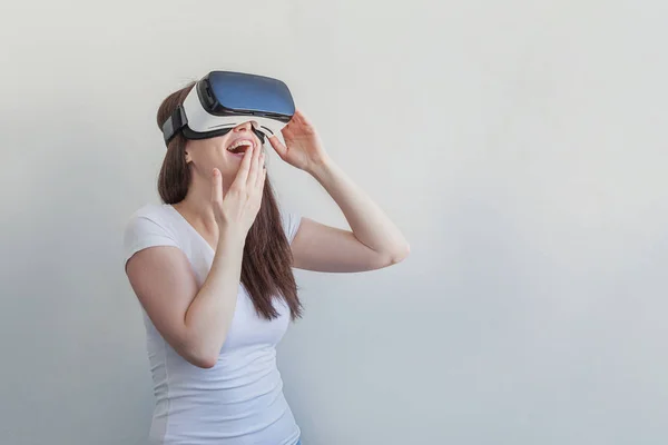 Sonríe mujer joven usando realidad virtual gafas VR casco auriculares sobre fondo blanco — Foto de Stock