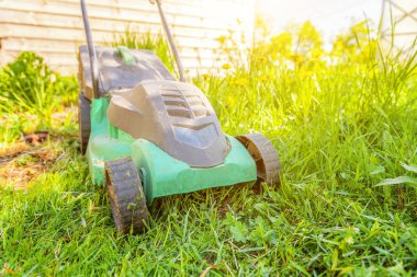 Çim biçme makinesi arka bahçesinde yeşil çim kesme