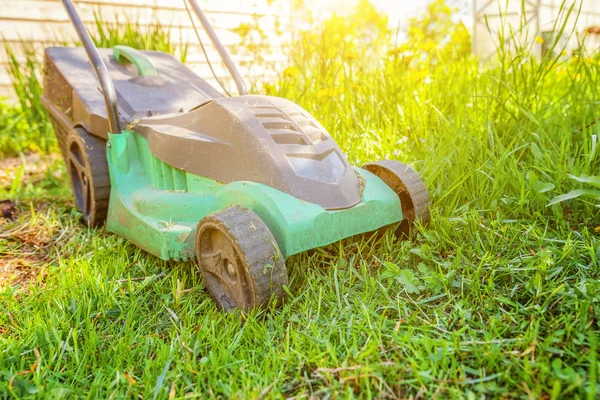 Lawn mower cutting green grass in backyard — Stock Photo, Image