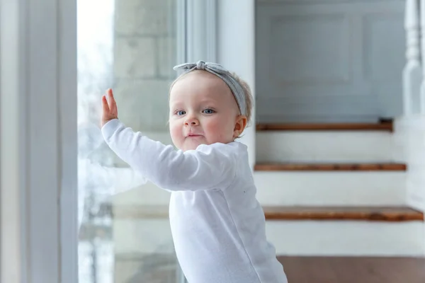 Kruipende babymeisje één jarige aanbrengen op de vloer in heldere lichte woonkamer in de buurt van venster glimlachen en lachen — Stockfoto