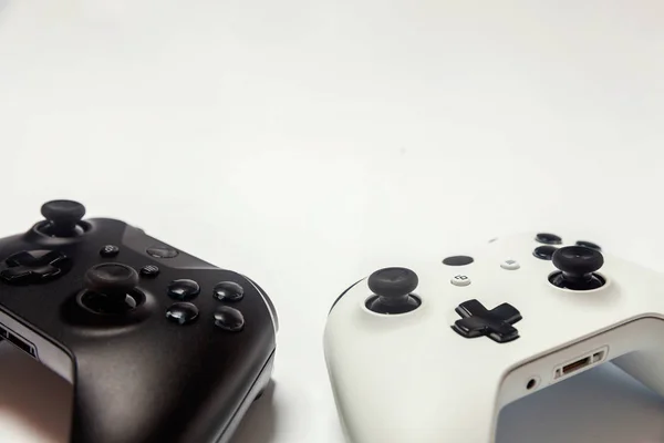 Branco e preto dois joystick no fundo branco. Tecnologia de jogos de computador jogar competição videogame controle confronto conceito — Fotografia de Stock