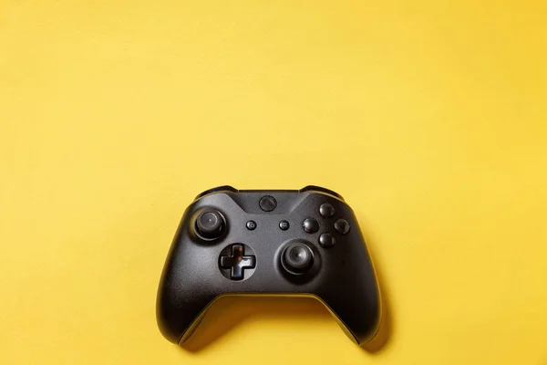 Musta joystick keltaisella taustalla. Tietokonepelien kilpailu videopelien valvonta vastakkainasettelu käsite — kuvapankkivalokuva
