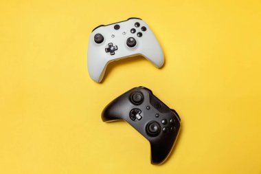 Sarı arka planda beyaz ve siyah iki joystick. Bilgisayar oyun Yarışması videogame kontrol çatışma kavramı
