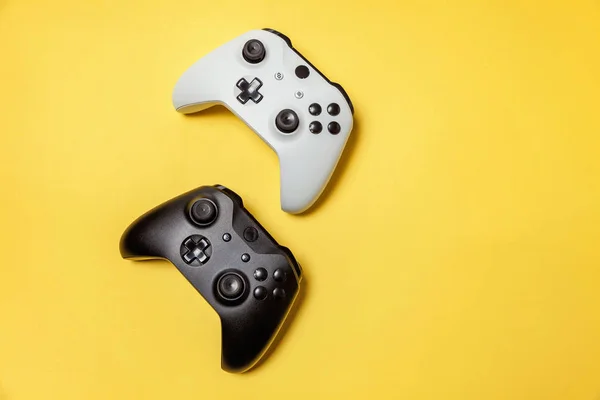 Blanc et noir deux joystick sur fond jaune. Concurrence de jeux vidéo concept de confrontation de contrôle de jeu vidéo — Photo