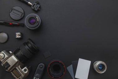 DSLR kamera sistemi, kamera Temizleme Kiti, koyu siyah masa arka planda objektif ve kamera aksesuarı ile fotoğrafçı çalışma alanı