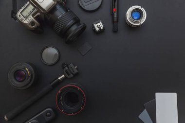 DSLR kamera sistemi, kamera Temizleme Kiti, koyu siyah masa arka planda objektif ve kamera aksesuarı ile fotoğrafçı çalışma alanı