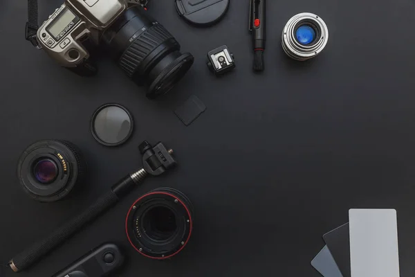 Φωτογράφος εργασίας με το σύστημα κάμερας DSLR, κιτ καθαρισμού κάμερας, φακό και Αξεσουάρ κάμερας σε σκούρο μαύρο φόντο τραπεζιού — Φωτογραφία Αρχείου