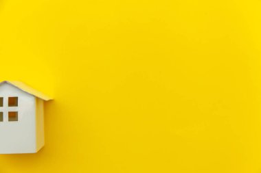 Sarı renkli trendy modern moda arka planda izole minyatür beyaz oyuncak ev ile sadece minimal tasarım
