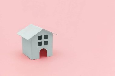 Pembe pastel renkli trendy arka planda izole minyatür beyaz oyuncak ev ile sadece minimal tasarım