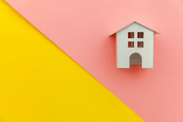 Po prostu minimalistyczny design z miniaturowym białym domem dla zabawek na żółto-różowe kolorowe modne nowoczesne pastelowe tło — Zdjęcie stockowe