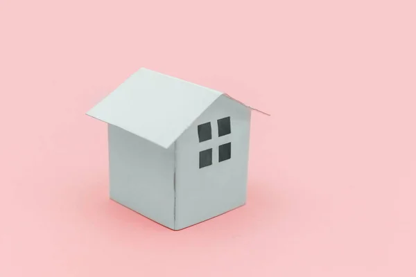 Simply minimal design with miniature white toy house isolated on pink pastel colorful trendy background