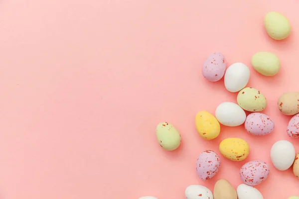 Buona Pasqua concetto. Uova di cioccolato caramelle pasquali e caramelle di gelatina isolate su sfondo rosa pastello alla moda. Semplice minimalismo piatto lay vista dall'alto copia spazio — Foto Stock