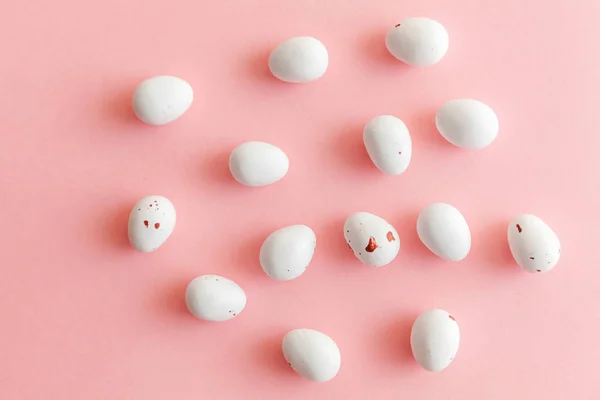 Feliz concepto de Pascua. Huevos de chocolate con caramelos de Pascua y dulces de gelatina aislados sobre un fondo rosa pastel de moda. Minimalismo simple plano laico vista superior copia espacio — Foto de Stock
