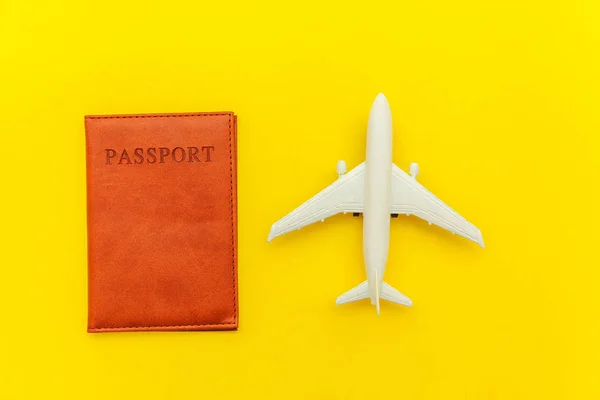 Mínimo simple plano laico viaje aventura concepto de viaje con avión y pasaporte en amarillo moderno fondo de moda — Foto de Stock