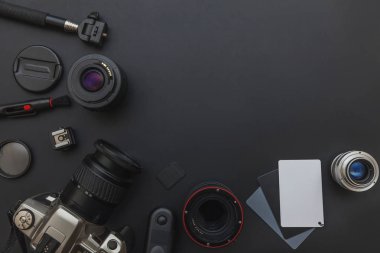DSLR kamera sistemi, kamera Temizleme Kiti, koyu siyah masa arka planda objektif ve kamera aksesuarı ile fotoğrafçı çalışma alanı