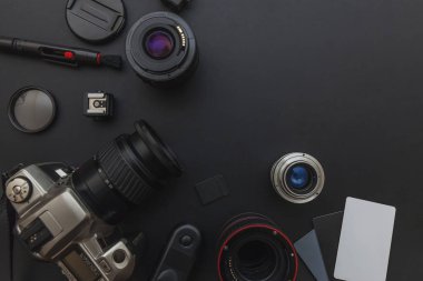 DSLR kamera sistemi, kamera Temizleme Kiti, koyu siyah masa arka planda objektif ve kamera aksesuarı ile fotoğrafçı çalışma alanı
