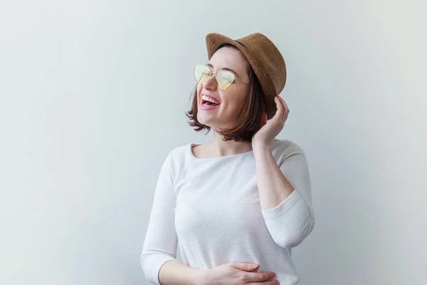 Retrato de estúdio simples de moda hipster menina sorridente em óculos de sol amarelos da moda e chapéu isolado no fundo branco — Fotografia de Stock