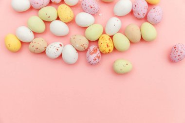 Mutlu Paskalya konsepti. Paskalya şekeri çikolata yumurta ve Jellybean tatlılar trendy pastel pembe arka planda izole. Basit minimalizm düz üst görünüm kopya alanı yatıyordu