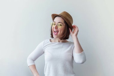 Şık yelow güneş gözlüğü ve şapka beyaz arka planda izole hipster moda gülümseyen kız basit stüdyo portre