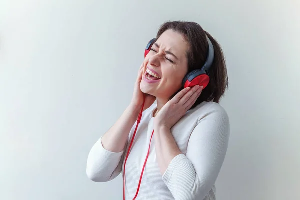 Energia jovem morena senhora mulher ouvindo música em fones de ouvido e cantando isolado no fundo branco — Fotografia de Stock