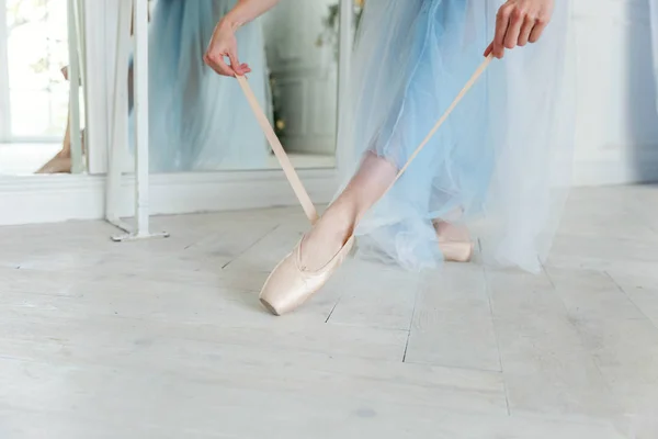 Baletka rukou vloží pointe boty na noze v taneční třídě — Stock fotografie