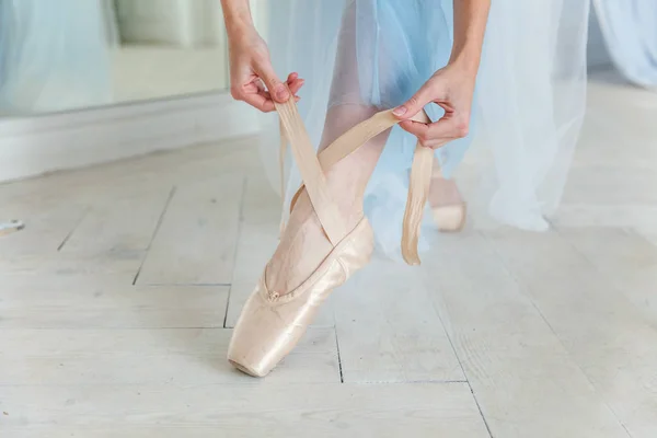 Bailarina manos pone zapatos puntiagudos en la pierna en clase de baile — Foto de Stock