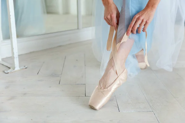 Bailarina manos pone zapatos puntiagudos en la pierna en clase de baile —  Fotos de Stock