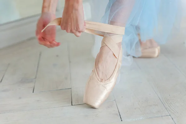 Bailarina manos pone zapatos puntiagudos en la pierna en clase de baile —  Fotos de Stock